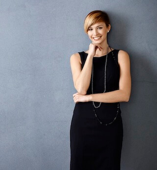 Beautify your smile at Caldwell Dentistry Co. Beautiful young woman in black dress touching her chin