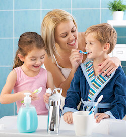 Mom, son, and daughter with brushing their teeth together in the bathroom