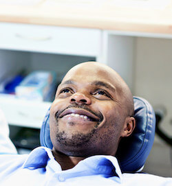 A dental patient looking relaxed, lying back, and smiling 