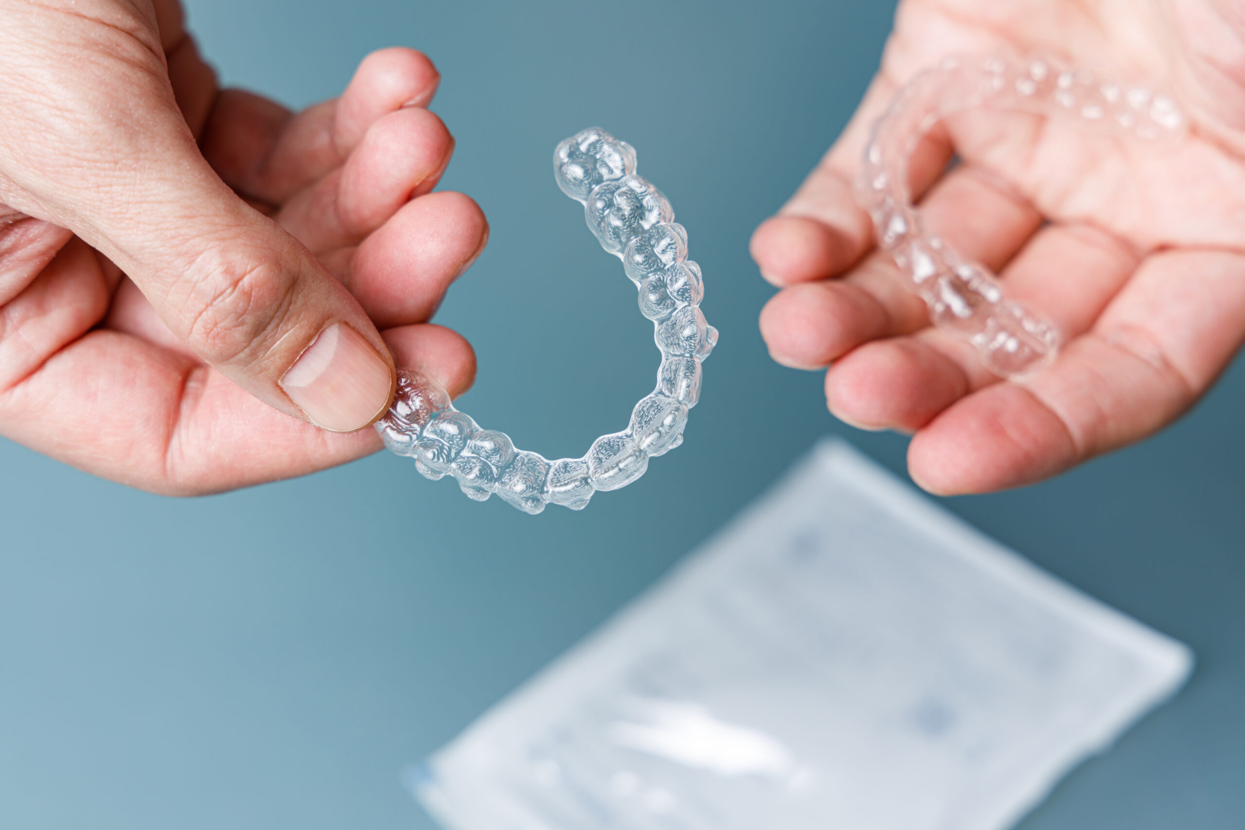 doctor holding invisalign teeth aligners