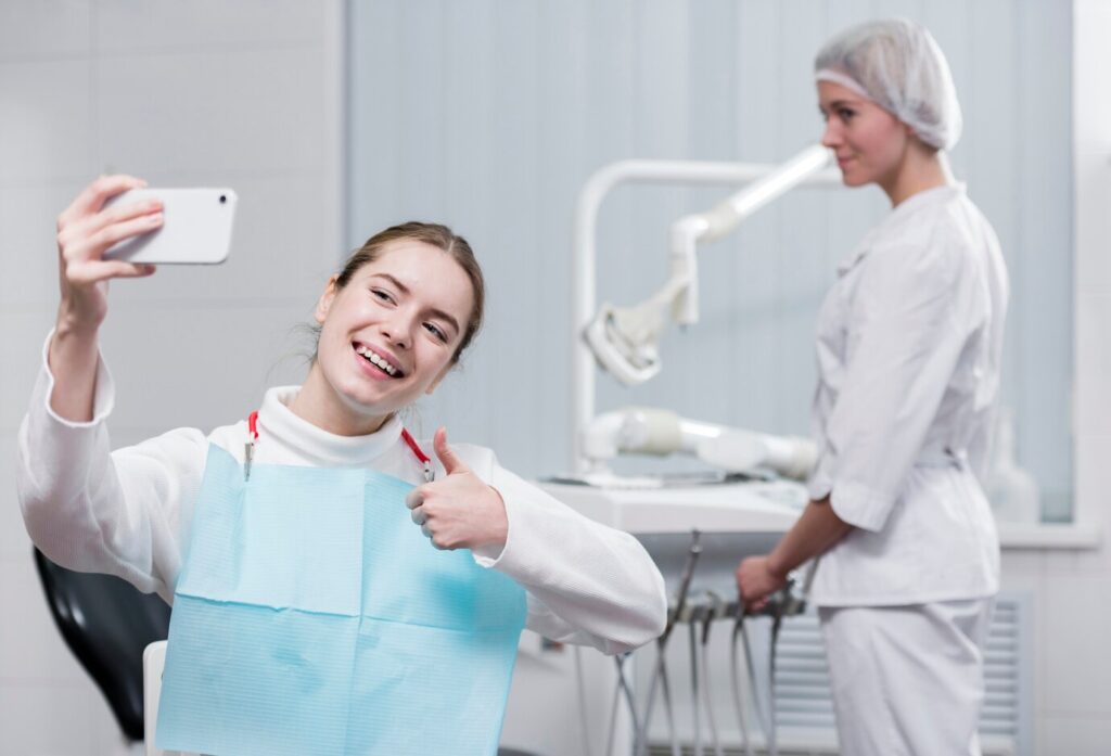 woman thumbs up teeth smile dentist